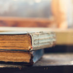 Stack of old books laid on windowsill
