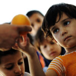 Hungry children in refugee camp, distribution of humanitarian food