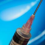 Syringe against blue background