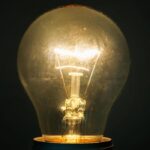 Glowing glass light bulb on dark background