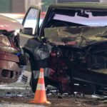 Damaged in heavy car accident vehicles after collision on city street crash site at night. Road safety and insurance concept.